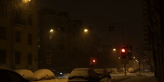 城市晚上下大雪。雪花照灯落在路上