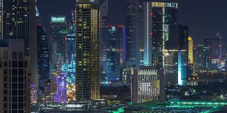 在阿拉伯联合酋长国迪拜市中心，空中城市景观在夜晚随着现代建筑的照明而流逝