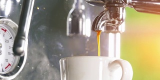 浓缩咖啡从经典的咖啡机倒入小的白色杯子。
