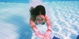 小女孩在游泳池里跳水