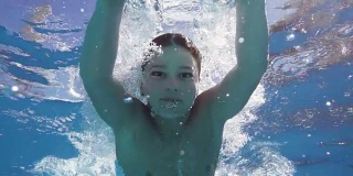 男孩在游泳池里跳水