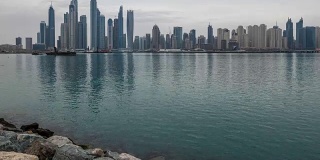 从朱美拉棕榈岛俯瞰迪拜现代摩天大楼的全景，从夜晚到白天