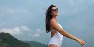 快乐美丽的女人在白色泳装摆姿势热带海滩