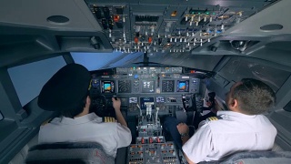 两名飞行员在飞行模拟器中操纵飞机。视频素材模板下载