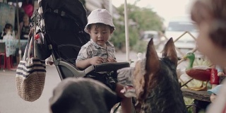 亚洲小男孩在跳蚤市场的婴儿车里。
