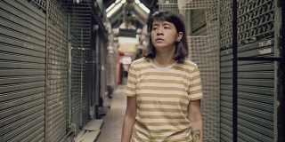 悲伤的年轻亚洲女人独自走在商店里