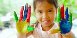 亚洲儿童展示她的绘画手的特写，慢动作拍摄100帧/秒