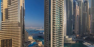 在阿联酋迪拜的迪拜码头，现代摩天大楼在日出的灯光下闪闪发光