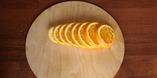 在木板上切熟橙子，特写。