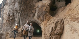 年轻的探险家戴着头盔从黑暗的大洞穴里走出来