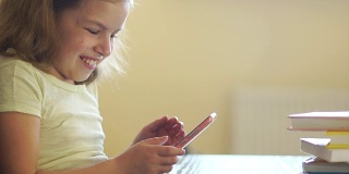 一个女孩正在玩手机游戏。网络成瘾。他巧妙地微笑。使用手机