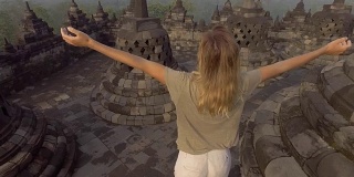 4K分辨率的视频旅行女孩拥抱日出在婆罗浮屠寺，印度尼西亚。People discovery Asia概念