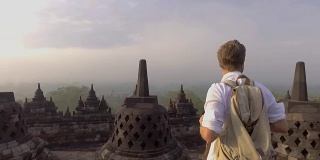 印尼婆罗浮屠寺，一名男子凝视日出的慢动作视频。人们旅行冒险的概念