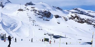 人们在马特霍恩克莱因的一个滑雪胜地滑雪，雪山和滑雪缆车的背景