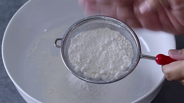 将面粉筛入白色搅拌盆中