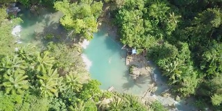 无人机航拍的年轻女子在热带瀑布游泳。4K分辨率的视频，在菲律宾拍摄。人们旅行乐趣度假冒险概念