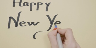 女人在贺卡上写着新年祝福，并用粗笔在上面划了下划线