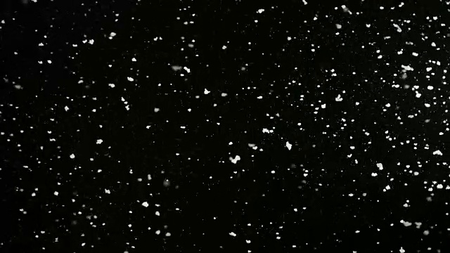 慢慢地飘落的蓬松的雪花孤立在黑色的背景，可循环。真实的镜头光晕，很容易使用混合/叠加模式。