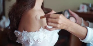 在婚礼当天，化妆师为新娘化妆。