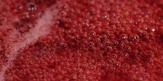 浓稠的红色液体中冒出的气泡构成了抽象的背景