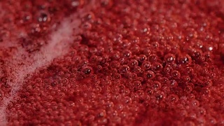 浓稠的红色液体中冒出的气泡构成了抽象的背景视频素材模板下载