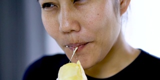 慢动作亚洲女子吃鲜皮榴莲。