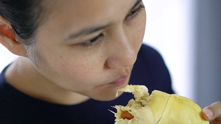 慢动作亚洲女子吃鲜皮榴莲。视频素材模板下载