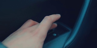 用手指按下车窗控制按钮。