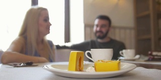 甜蜜的甜点面前的情侣坐在咖啡馆享受咖啡和大笑