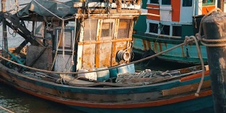 一艘半毁的旧木船停泊在一个捕鱼码头上