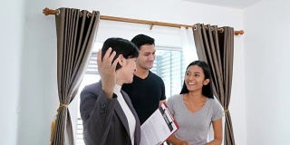 年轻夫妇寻找购买/租用新房。专业的房地产中介为客户呈现现代住宅。4 k决议。