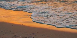 非常美丽的日落在海边。沙滩和海浪拍打着沙滩
