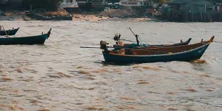 小渔船在波涛汹涌的海面上航行。渔民在海里捉鱼