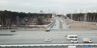 在晴朗的清晨，州际通勤交通过桥鸟瞰图。视频。航拍高速公路和天桥与汽车和卡车的城市生活
