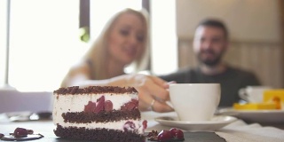 甜蜜的蛋糕面前的情侣坐在咖啡馆享受谈话