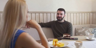 一个年轻的白人男人在咖啡馆里和一个女人聊天