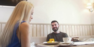 一对快乐的情侣在咖啡馆里聊天，互相看着对方