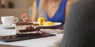 一块甜蛋糕在一个女人面前品尝甜点在咖啡馆