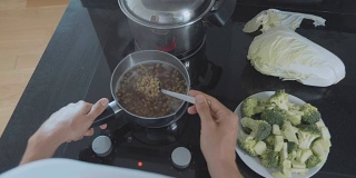POV的手用勺子搅拌煮扁豆的蔬菜汤，特写。