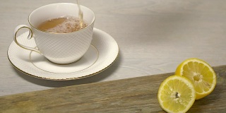 茶水倒入木桌上的白色茶杯中