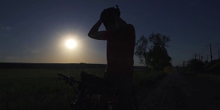 一个年轻人在日落时分积极地骑着自行车