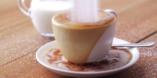 咖啡和糖洒在桌上的杯子里