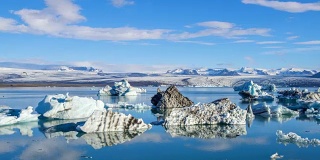 4k时间移动的云与蓝色冰山漂浮在Jokulsarlon冰湖，冰岛