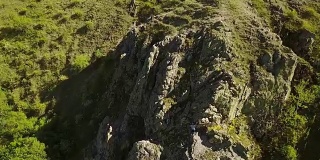 鸟瞰图男子独自自由攀登悬崖。雄性攀爬岩石没有安全带和绳索。孤身登山的人