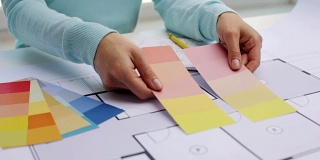 女人用房子的蓝图和样本选择颜色