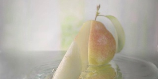 梨在水中切成薄片。慢动作镜头