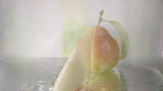 梨在水中切成薄片。慢动作镜头视频素材模板下载