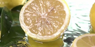 柠檬半片碰到淡水表面。慢动作镜头