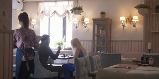 一对年轻夫妇拿着菜单在咖啡馆点餐