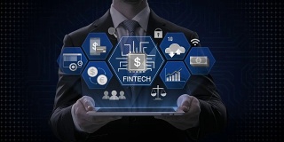 商人举着智能pad，平板电脑，金融科技图标和各种图形。未来的金融技术。4 k的电影。版本3。
